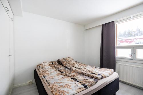 een bed in een kamer met een raam bij Santas Duplex II in Rovaniemi