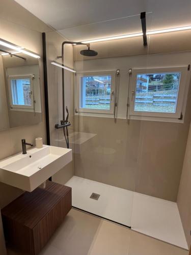 Un baño con lavabo y ducha en Renovated-Spacious apartment up to 6 people in Flims, en Flims
