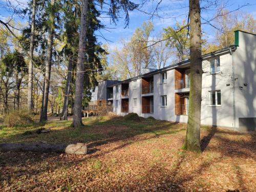 Una vista exterior de un edificio blanco en el bosque. en Apartamenty Dąbrówka Cieplice Zdrój, en Jelenia Góra