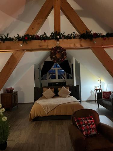een slaapkamer met een groot bed op de zolder bij Les Villas du Ried in Daubensand