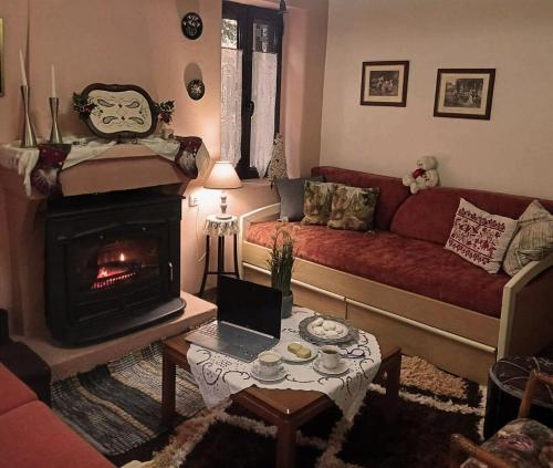 uma sala de estar com sofá e lareira em Vrachni Stone House em Ano Zachlorou