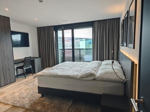 a bedroom with a bed and a window with a desk at Sun Tower in Zurich