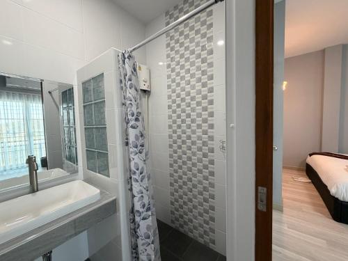 Un baño con lavabo, bañera y ducha. en Home Hug You, en Chiang Mai