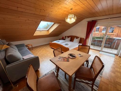 een woonkamer met een bank, een bed en een tafel bij Villa am Goldbach in Bad Aibling