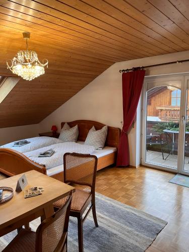 a bedroom with a bed and a table with chairs at Villa am Goldbach in Bad Aibling