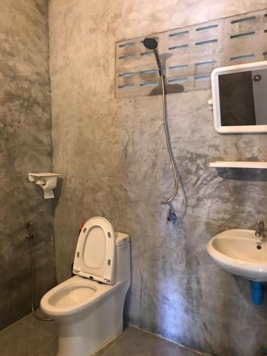 a bathroom with a toilet and a sink at Suan Proud Koh yao noi in Ko Yao Noi