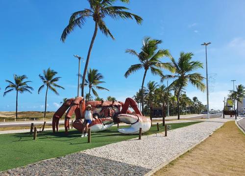 un hombre está parado frente a un patio de recreo en Pousada na Orla, Atalaia, en Aracaju
