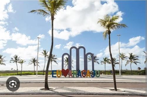 Un estacionamiento con palmeras y un monumento. en Pousada na Orla, Atalaia, en Aracaju