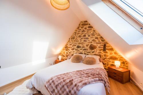 ein Schlafzimmer mit einem Bett auf einem Dachboden in der Unterkunft Le Refuge de la Clarté, draps et serviettes inclus in Perros-Guirec