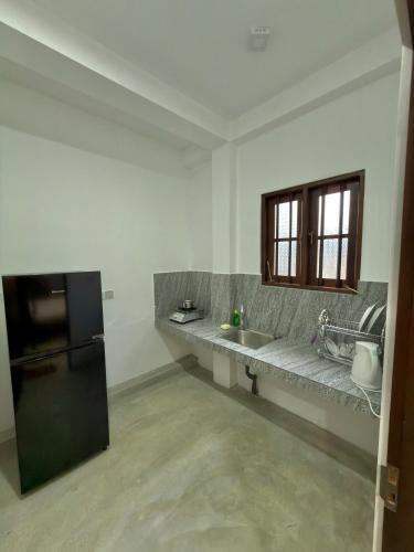 a kitchen with a counter with a sink and a refrigerator at Sayuru Villa in Hikkaduwa