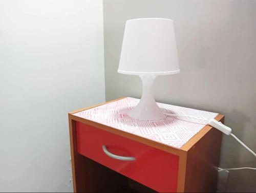 Casa Happy - La mansarda del sorriso con parcheggio privato a Valcorrente في بيلباسو: مصباح على خزانة ملابس وعليه ورقة