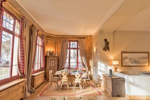 a dining room with a table and chairs and windows at casa storica nel centro di Bever 4 camere in Bever