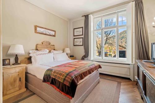 a bedroom with a bed and a large window at casa storica nel centro di Bever 4 camere in Bever