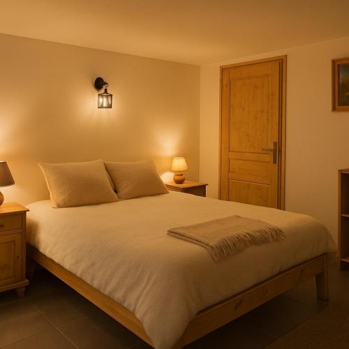 a bedroom with a bed with two lamps and a door at Le JoliCoeur Parking gratuit Idéal cyclistes Proche Alpe d Huez in Le Bourg-dʼOisans