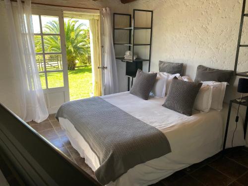 una camera da letto con un letto grande con lenzuola e cuscini bianchi di Hus Punta Rubia a La Pedrera