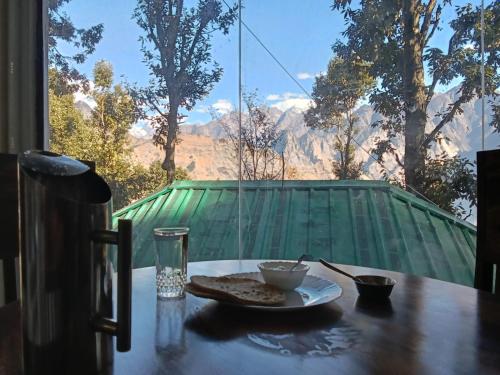 a plate of food sitting on a table with a view at TTN - The Trekker's Nest in Joshīmath