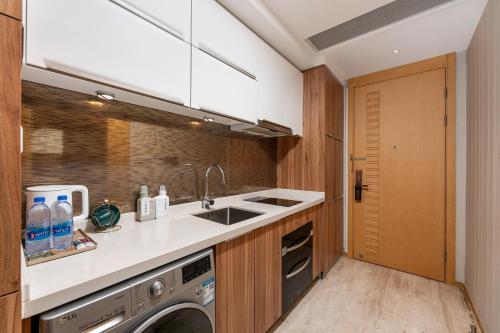 a kitchen with a sink and a washing machine at Yizhimei Apartment Hotel-Guangzhou Huijin International Financial Center Keyun Road Subway STN Branch in Guangzhou