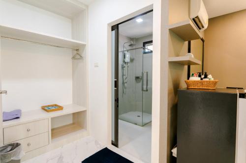 a bathroom with a walk in shower and a glass shower stall at Neenlawat Riverside in Surat Thani