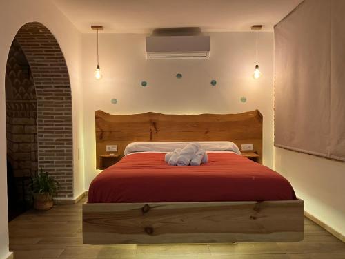 a bedroom with a bed with a red blanket at Los Siete Arcos in Granada