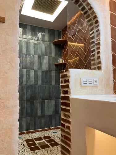 baño con pared de piedra y lavamanos en Los Siete Arcos, en Granada