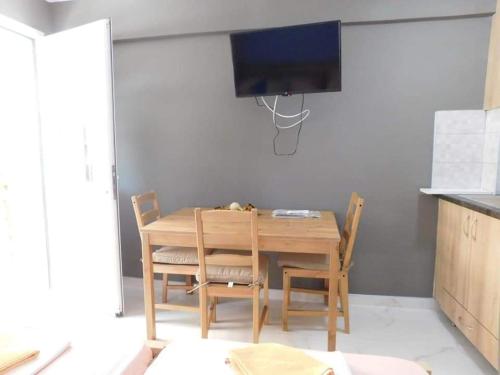 mesa de comedor con 2 sillas y TV en Corner Studios, en Perea