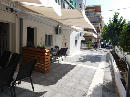 um pátio externo com cadeiras e um guarda-sol em Corner Studios em Perea