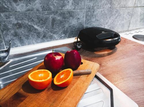 een snijplank met appels en sinaasappels op een aanrecht bij OINO APARTMENT in Corfu-stad