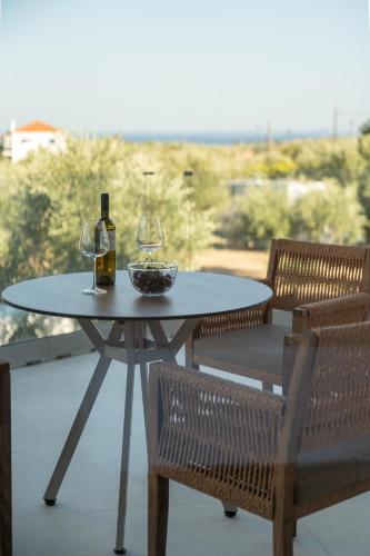 a table with two wine glasses and a bowl of grapes at Liokrina suites in Koroni