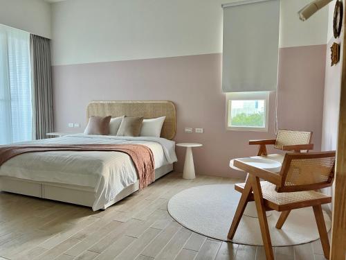 a bedroom with a bed and a chair and a table at 靜沐森林 in Dongshan