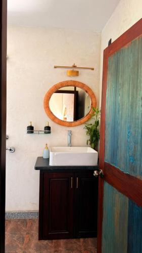 a bathroom with a sink and a mirror at Chique Shanti Villa in Mandrem