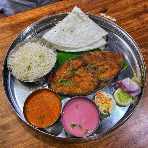 a tray of food with rice and meat on a table at Chaitanya Beach Reesort in Dapoli