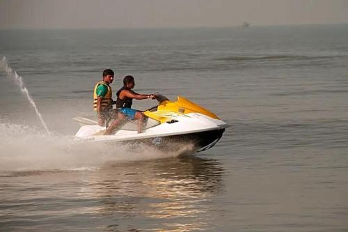 twee mannen op een jetski in het water bij Chaitanya Beach Reesort in Dapoli