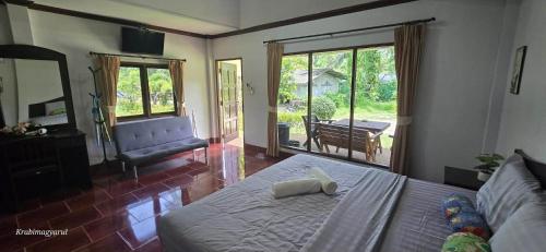 a bedroom with a bed and a living room at Sabai Resort in Ao Nang Beach