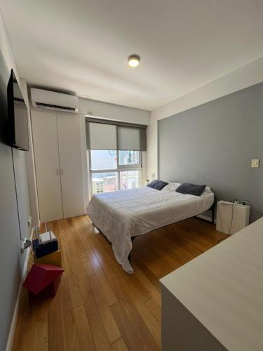 a bedroom with a bed and a large window at Apartamento para 2 personas in Buenos Aires