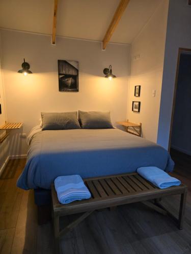 Refugio Ecos del Bosque في بورتو فاراس: غرفة نوم بسرير كبير مع وسائد زرقاء