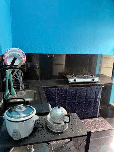 cocina con encimera con olla y fregadero en J&N Homestay, en Skudai