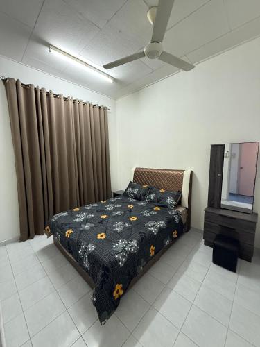 Un dormitorio con una cama y un ventilador de techo. en J&N Homestay, en Skudai