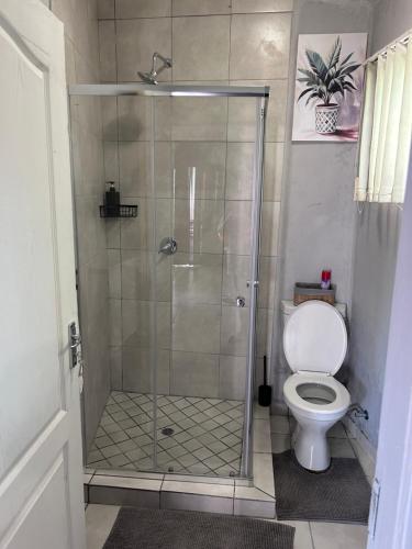 a shower stall with a toilet in a bathroom at Cozy pool side cottage in Roodepoort
