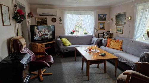 una sala de estar con un sofá y una mesa en Mor's hus, en Vestvågøya