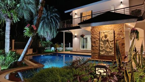a villa with a swimming pool in front of a house at Wonderful Beach Villa, Perfect Location in Khao Lak