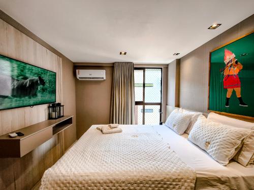 若昂佩索阿Cobertura com jacuzzi a 130m da praia de Tambaú的卧室里有一张床，墙上挂着一幅画