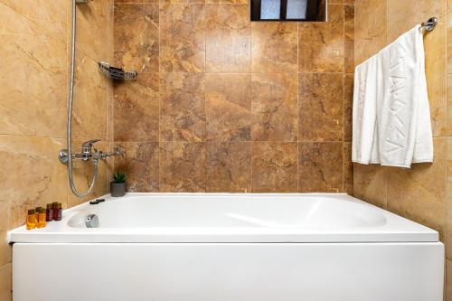 a white bath tub in a bathroom with a shower at Vacation Apartment in Starosel POOL & SPA in Starosel