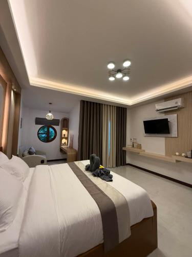 a bedroom with a large bed with a teddy bear on it at The Cushty Days Lanta in Ko Lanta