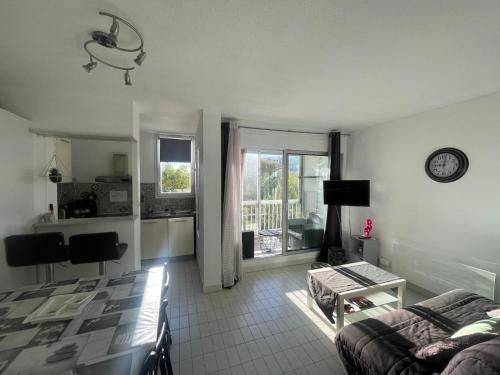 ein Wohnzimmer mit Sofa und Tisch in der Unterkunft Grand studio au Grau-du-Roi proche Seaquarium et plage in Le Grau-du-Roi