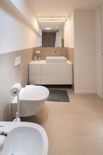 a bathroom with a white toilet and a sink at Sarius Relais 2 in Seriate