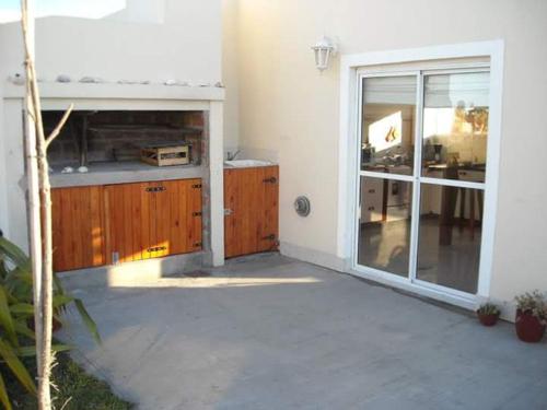 een keuken met houten kasten en een glazen schuifdeur bij Casa en Mar de Cobo in Mar de Cobo
