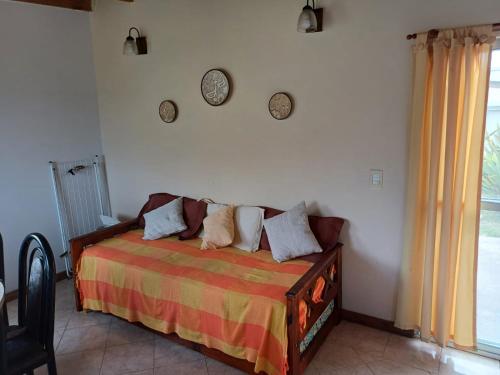 een slaapkamer met een bed en twee klokken aan de muur bij Casa en Mar de Cobo in Mar de Cobo