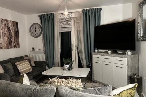 a living room with a couch and a flat screen tv at Coastal Comfort - Two Bed Terrace on Barry Island in Barry