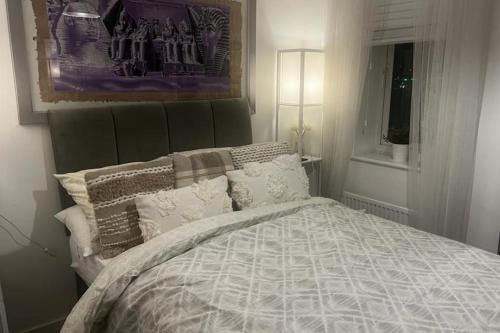 a bedroom with a bed with a blanket and pillows at Coastal Comfort - Two Bed Terrace on Barry Island in Barry