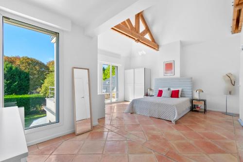 a bedroom with a bed and a large window at Villa Séquoia Saint-Germain-en-Laye in Saint-Germain-en-Laye